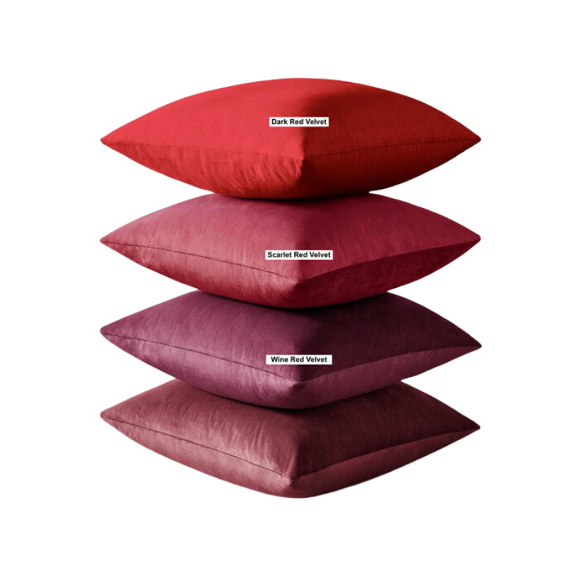 A stack of four throw pillows in dark red velvet, scarlet red velvet, and wine red velvet.