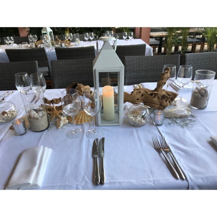 White lantern with candle on table