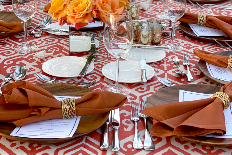 Table setting with burnt orange table linens and wood chargers